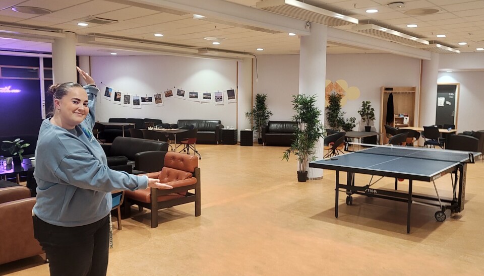 Vilde står i cafe bodega, og viser bordtennisbordet og lokalet.