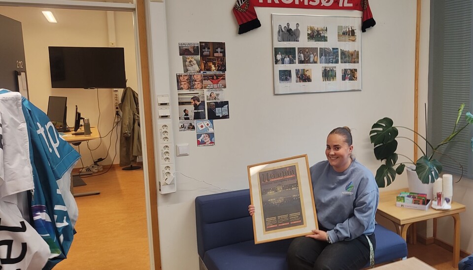 Vilde sitter på Arbeidsutvalget sitt kontor og viser frem en gammel plakat av Utropia den tidligere studentavisen på UiT.